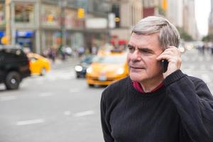 senior man praten op mobiele telefoon in New York foto