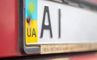 Oekraïens autoregistratienummer met nationale vlag en wapenschild. regiocode, kiev regio ai, 10 regio. autonummer zonder nummers op de voorbumper van de auto, close-up. foto