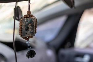 het icoon-amulet in de auto van nicholas de wonderdoener aan een koord. de badge hangt handig aan de achteruitkijkspiegel in de auto. vertaling serafijnen van sarov de wonderdoener. foto