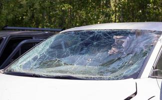 close-up van een auto met een gebroken voorruit na een dodelijke crash. gevolg van een dodelijk auto-ongeluk. auto gevaar. roekeloos gevaarlijk rijgedrag. voertuig na een ongeval met een voetganger. foto