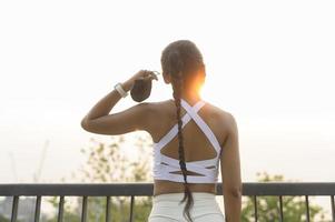 jonge fitnessvrouw in sportkleding die gezichtsmasker afdoet tijdens het sporten in het stadspark, gezondheid en levensstijl. foto