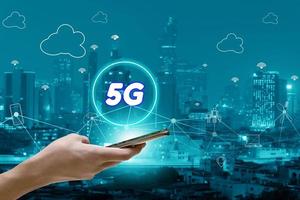 5g netwerkinterface en pictogram concept, hand met mobiele smartphone met stadsgezicht foto