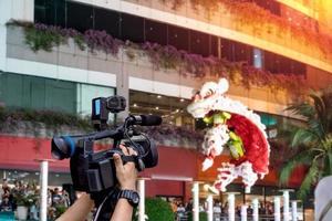 hand met een videocamera met leeuwendans vage achtergrond, Chinees nieuwjaarsfestival foto
