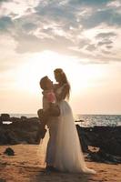 bruiloft op het strand. jong en mooi getrouwd stel in omhelzing. foto