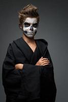 tiener met make-up van de schedel in zwarte cape