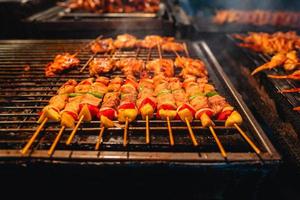 barbecuespiesjes op een straatgrill foto