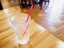 glas water op houten tafel in restaurant foto