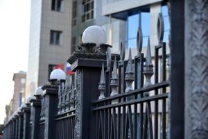 ijzeren hek met pinnen en lantaarns in de stad foto