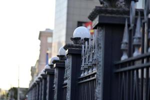 ijzeren hek met pinnen en lantaarns in de stad foto