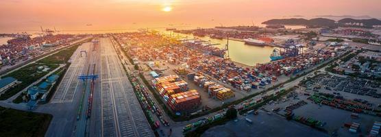 het internationale vrachtcontainerdepot bij zonsondergang, meerdere supply chain vrachtwagentrein en vrachtschip werkservice verzending en transportconcept logistiek en transport. foto