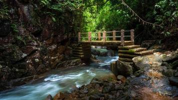 oude brug over natuurlijke stroom waterval en groen bos in het bergconcept reizen en ontspannen op vakantie. foto