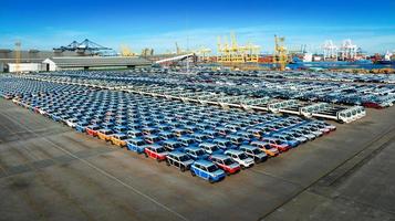 luchtfoto veel nieuwe auto voor import en export verzending per schip, smart dealership bij autodepot, auto op parkeerplaats voor verzending naar klant, auto na productie bij smart factory industrie foto