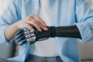 cyberhand van vrouwelijke geamputeerde. gehandicapte vrouw verandert instellingen van robotprothese. foto