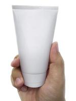 menselijke hand met cosmetische plastic buis geïsoleerd op een witte achtergrond foto