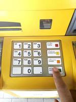 close-up van de hand die de pincode invoert op het toetsenbord van de bankautomaat foto