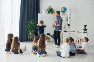 whiteboard gebruiken. groep kinderen studenten in de klas op school met leraar foto