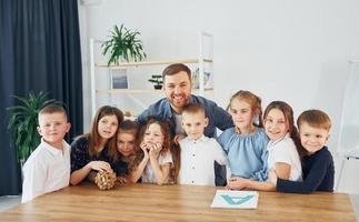 staan en poseren. samen lachen. groep kinderen studenten in de klas op school met leraar foto