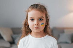 portret van meisje met Oekraïense vlag make-up op het gezicht foto