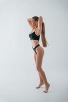 model is tegen een witte achtergrond. vrouw in ondergoed met slank lichaamstype poseert in de studio foto