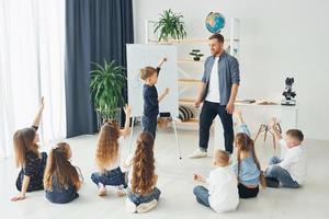 op het bord schrijven. groep kinderen studenten in de klas op school met leraar foto