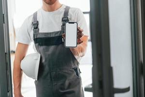 reparateur staat binnen in de moderne kamer foto