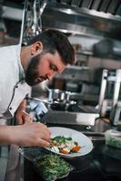 twee broers maken salade. professionele chef-kok die voedsel in de keuken bereidt foto