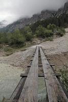 houten brug over een bergrivier in de alpen foto