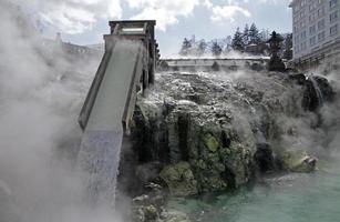 heet water gutst langs een houten helling in kusatsu onsen in japan foto