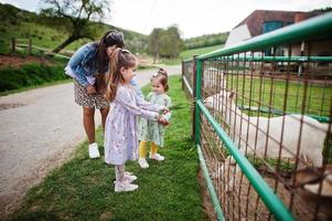 moeder met kinderen op een eco-boerderij met dierenvoer geiten. foto