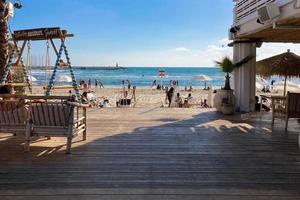 tel aviv, Israël, 15 mei 2022. openlucht strandrestaurant met mensen die op het strand rusten foto