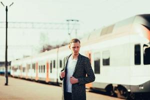 man die op een modern treinstation staat foto