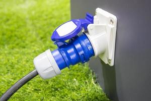 stopcontact draagbare stroom elektriciteit op gras voor gebruik wanneer caravan camping buiten foto