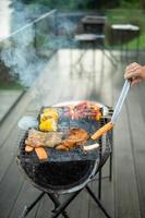 heerlijk gegrild vlees met rook, bbq met groenten in de buitenlucht. barbecue, feest, lifestyle en picknick concept foto