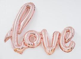 opblaasbare woord liefde in de buurt van witte muur. ballon letters foto