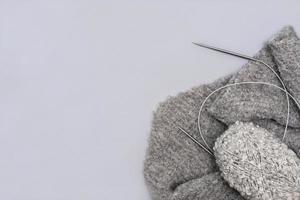 grijs breigaren in een streng met naalden en een sjaal foto