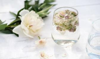 een glas met met bloemen doordrenkte drank foto