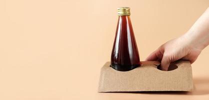 cold brew koffie in glazen fles. koffie om te gaan concept. biologisch afbreekbare houder van karton of papier, eco-verpakking voor dagelijkse drankjes, banner foto