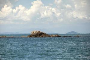natuurlijke rots over blauwe zee in rayong, ten oosten van thailand foto