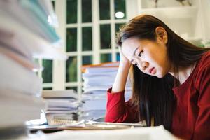 een stressvrouw heeft hoofdpijn tijdens het werken met een laptop in een nachtelijke coworking-ruimte foto