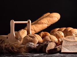 een groep brood op de houten tafel en zwarte achtergrond foto