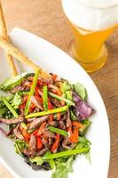 plaat van salade van vlees met groenten en lichte beer foto