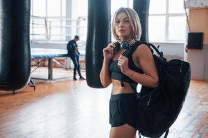 volwassen vrouw met zwarte tas en koptelefoon in de trainingsgymnastiek foto