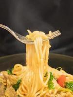 hete en pittige spaghetti met vork op zwarte achtergrond foto