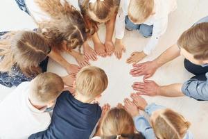 bovenaanzicht. man met zijn kinderen studenten in hand in hand voor succes. opvatting van onderwijs foto