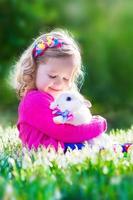 mooi meisje speelt met een konijn foto