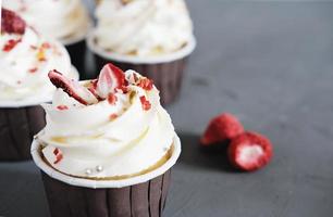 close-up van zelfgemaakte cupcakes met creamcheese frosting en droge aardbeiendecoratie. selectieve aandacht. zomerfeestmenu foto