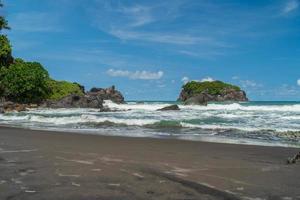 natuurlijk uitzicht op de kust in Indonesië bij zonnig weer. karang tawulan strandtoerisme in indonesië foto