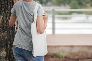 hipster vrouw met witte katoenen tas in het park foto