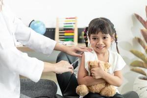 succesvolle covid-19-vaccinatie. schattig klein meisje terwijl ze wordt ingeënt tegen het coronavirus foto