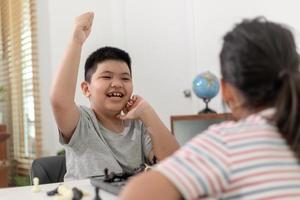 kleine jongen en meisje spelen thuis schaken. kinderen schaken foto